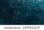 Aerial view of the dark blue ocean with textured water patterns and light reflections. Drobe Shot