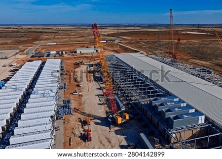Aerial view of data center construction with BESS batteries and red cranes