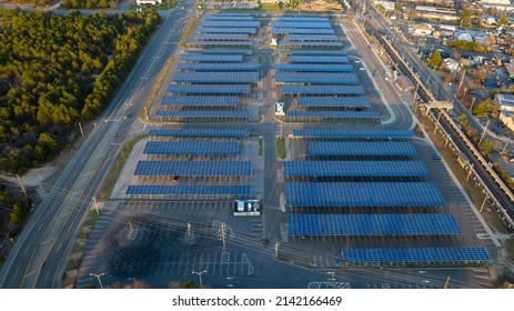 An Aerial View Of The Deer Park Long Island Railroad Station Parking Lot With Car Shelters With Solar Panels On The Roof. Shot Taken At Sunset By Drone Camera.