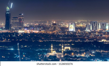 Aerial View To Deira District With Airport On Background Timelapse And Illuminated Buildings. Top View From Dubai Downtown. Traffic On The Road. Dubai, UAE