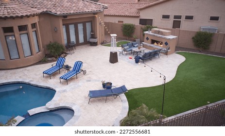 An aerial view of a desert landscaped backyard in Arizona featuring a travertine pool deck and fireplace.