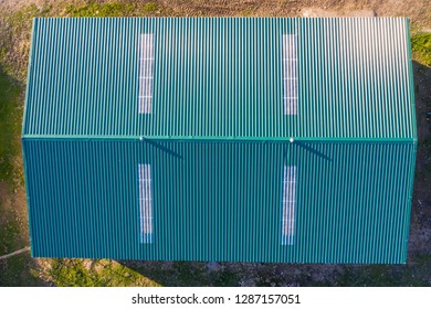 An aerial view directly above of the amazing "Dehesa Extremeña" with a modern shed warehouse with metal sheet roof. Storage in the past at the Spanish countryside in Extremadura region
