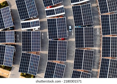 Aerial View Directly Above Electric Cars Parking Under Solar Panels On A Parking Lot Rooftop Ready For Charging In An Innovative Technology Concept