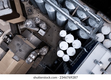 Aerial view directly view above large storage tanks in a row for food production or chemical storage at an industrial plant or factory - Powered by Shutterstock