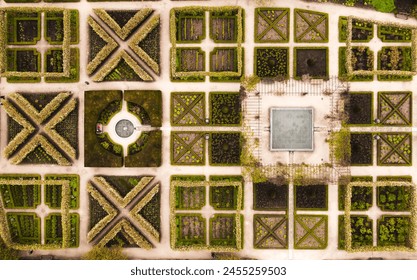 Aerial view directly above rows of landscaped flower beds in an English formal garden with water features - Powered by Shutterstock