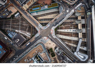 An Aerial View Directly Above An Urban Metropolis With Crossroad Street Junction Over Busy Railway Lines