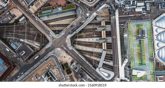 An Aerial View Directly Above An Urban Metropolis With Crossroad Street Junction Over Busy Railway Lines