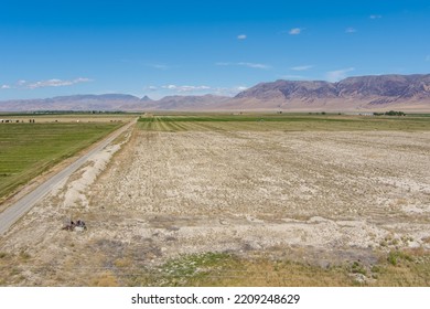 Aerial View Of A Dirt Road Running Through An Agricultural Field In The Arid Nevada Desert.