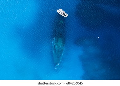 Aerial View Of A Dive Boat Over A Large Underwater Shipwreck In Clear, Blue, Tropical Waters