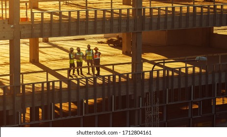 Aerial View: Diverse Team Of Specialists Inspect Commercial, Industrial Building / Skyscraper Formwork Construction Site. Real Estate Project Lead By Civil Engineer, Investor, Architect And Worker