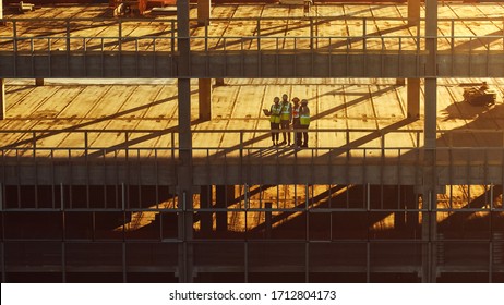 Aerial View: Diverse Team Of Specialists Inspect Commercial, Industrial Building / Skyscraper Formwork Construction Site. Real Estate Project Lead By Civil Engineer, Investor, Architect And Worker