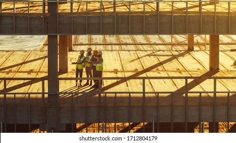 Aerial View: Diverse Team Of Specialists Inspect Commercial, Industrial Building / Skyscraper Formwork Construction Site. Real Estate Project Lead By Civil Engineer, Investor, Architect And Worker