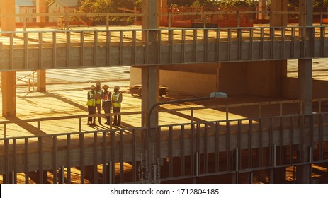 Aerial View: Diverse Team Of Specialists Inspect Commercial, Industrial Building / Skyscraper Formwork Construction Site. Real Estate Project Lead By Civil Engineer, Investor, Architect And Worker