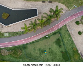 Aerial View Of Dog Place In Ilha Pura Park At Sunset. Coconut Trees, Water Mirror And Running Track Next Door. Rio De Janeiro, Brazil. Sunny Day. Top View. Drone Take.