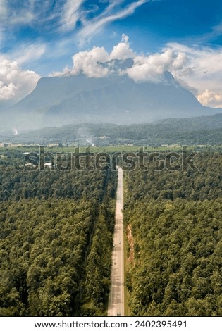 Aerial view of Doi Luang Chiang Dao mountain with a straight road among the forest on bright day at Chiang Dao, Chiang Mai, Thailand. aerial view of drone flying, The road leads beautifully to montain