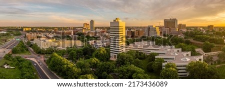 Aerial view of downtown New Brunswick, New Jersey with dramatic colorful sunset sky low rise apartment buildings and first reformed church, high rise office buildings, parking lots