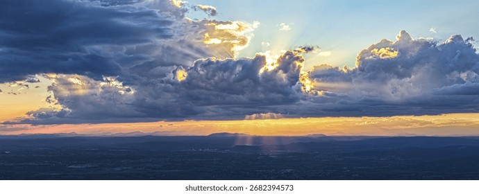 Aerial view of dramatic cloud formation with sun rays piercing the clouds