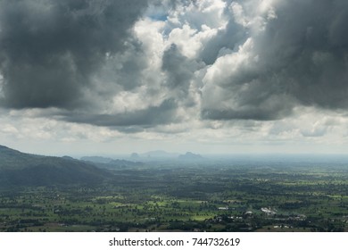 Aerial view of dramatic cloud and green land with mountain.