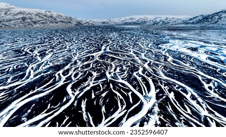 Aerial view of the dramatic contrasts of the landscape after the flow of glacial rivers in Iceland.
