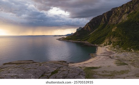 Aerial view of Dramatic evening storm clouds at stunning evening over the beach at Mjelle in Northern Norway pouring rain with fisher boat in the bay
