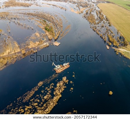 Aerial view of dredge replenish sand in river. Canal is being dredged by excavator. Top view of dredging boat crane. Industrial concept.
