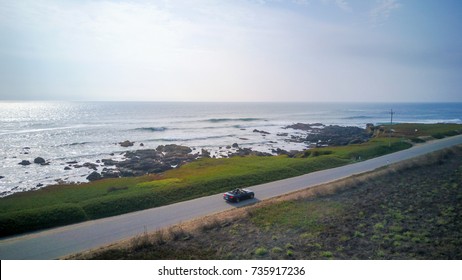 Aerial view of driving in a Ford Mustang convertible down the ocean road in California near the Pigeon Point lighthouse. - Powered by Shutterstock