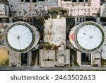 Aerial view from drone of abandoned and ruined Nuclear Power Plant or station, round tower of atomic reactor, large industrial demolished building. High quality photo