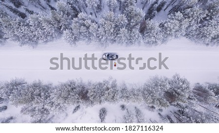 Aerial view from drone of car stopping to pick up hitchhikers explore wild destinations on journey, bird’s eye view of two persons get into transport discover north cold lands on road trip in winter