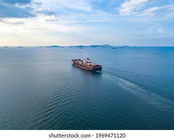 Aerial view from drone, Cargo vessel sail to the sea with peaceful wave in beautiful scenic sky. Professional business logistics and transportation of cargo ship.