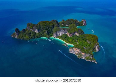 Aerial view of drone flying above amazing tropical island, bay, Steep cliffs and Longtail boats moving on beautiful turquoise water in Krabi Thailand.