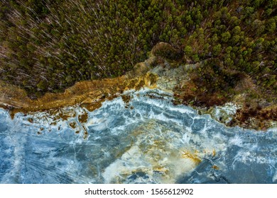 Aerial view drone flying forward over polluted river with destroyed ecosystem and copper tailing dump poisoning ground and water air emissions from industry environmental disaster in South Ural