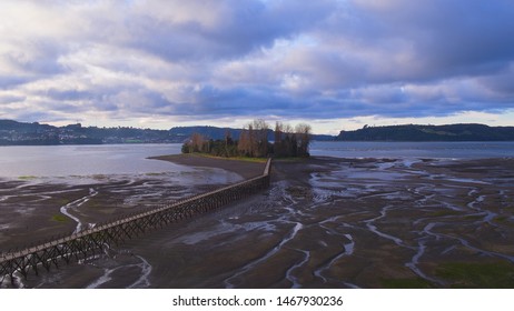 Aerial View With Drone Of The Iconic Aucar Island That Has A Bridge Made Of Wood. This Island That Is Near The Town Of Quemchi In The Chiloé Archipelago 