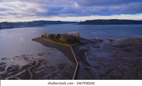 Aerial View With Drone Of The Iconic Aucar Island That Has A Bridge Made Of Wood. This Island That Is Near The Town Of Quemchi In The Chiloé Archipelago 