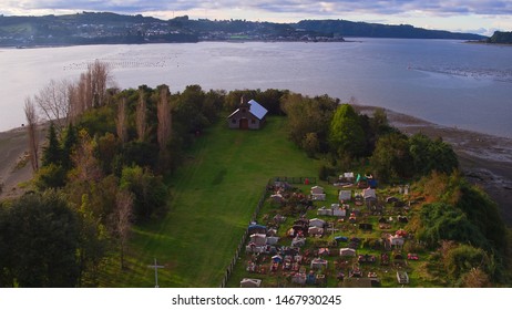 Aerial View With Drone Of The Iconic Aucar Island That Has A Bridge Made Of Wood. This Island That Is Near The Town Of Quemchi In The Chiloé Archipelago 