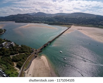 Aerial View, Drone Panorama Over Rising Tide Sea, Bay, Anchored Boats, Steel Railway Bridge In Barmouth, Wales