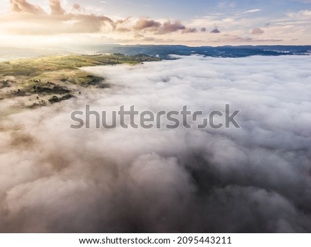 Aerial view from drone of sea of clouds in the morning over the mountains hills and farmland at Khao Kho, Phetchabun, Thailand.
Foggy and cloud inversion over the mountains.
