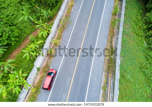 Aerial view Drone\
shot of red suv car on\
road.