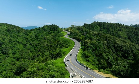aerial view drone shot ROAD No.1081 or shape number three of winding mountain road between Pua District, Nan Province, Thailand is highlight point and landmark that tourist like to take pictures