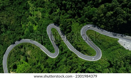 aerial view drone shot ROAD No.1081 or shape number three of winding mountain road between Pua District, Nan Province, Thailand is highlight point and landmark that tourist like to take pictures 