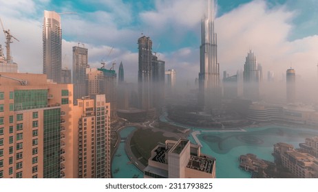 Aerial view of Dubai city early morning during fog timelapse. Sunrise at futuristic city skyline with skyscrapers and towers from above. Sun reflected from glass surface with rays of light - Shutterstock ID 2311793825