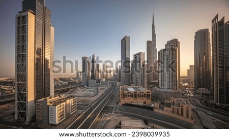 Aerial view of Dubai Downtown skyline during sunrise with long moving shadows from tall towers timelapse. Business area in smart urban city. Skyscrapers and high-rise buildings from above, UAE.