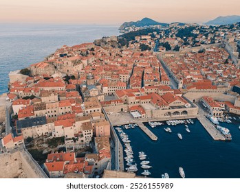 Aerial view of Dubrovnik's old town showcasing historic buildings and vibrant sunset colors along the Adriatic Sea - Powered by Shutterstock