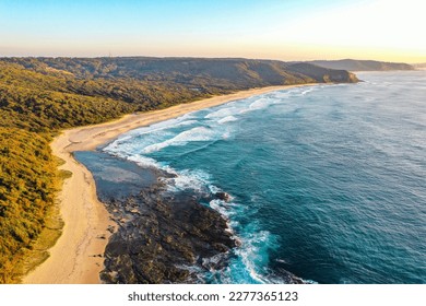 Aerial view of Dudley beach and surrounding coastline with beautiful blue ocean and golden bushland