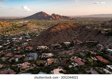 Aerial view during sunset of Paradise Valley and Scottsdale, Arizona with Camelback Mountain and surrounding Phoenix landscape and neighborhoods