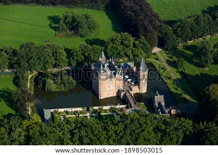 Aerial view of Dutch medieval castle in the area of Heeswijk Dinther, Holland. The 1000 year old fort is surrounded by a moat. It is late in the afternoon so long shadows over the green woods. Stock photo © 