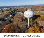 Aerial view of Eau Claire, Wisconsin, water tower.  Fall foliage present in landscape.  Residential area seen.   Industrial area seen in far top.  Blue sunny sky on fall day.  