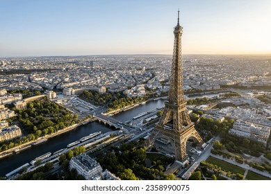 aerial view of the Eiffel tower on the banks of the river Seine, with the city of paris on the horizon.