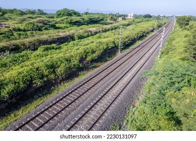 Aerial view of electrified railway tracks on the Pune to Daund route amidst green landscape at Uruli near Pune India.