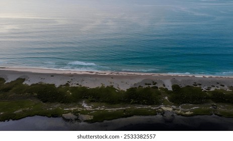 Aerial view of an empty beach with turquoise water and green vegetation, showcasing the serene coastline and calm sea. - Powered by Shutterstock