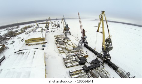 Aerial view to empty cargo dock with cranes and containers in the winter